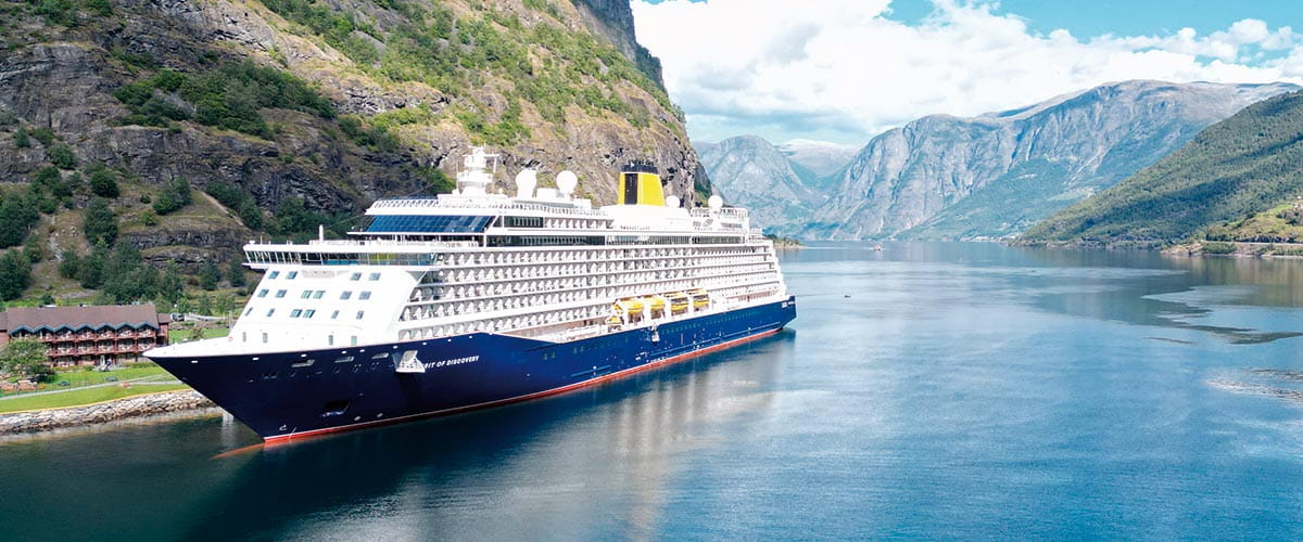 Spirit of Discovery sailing down a fjord in Flåm, Norway